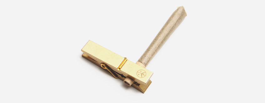 Brass Roach Clip Een gouden wasknijper met een houten handvat.