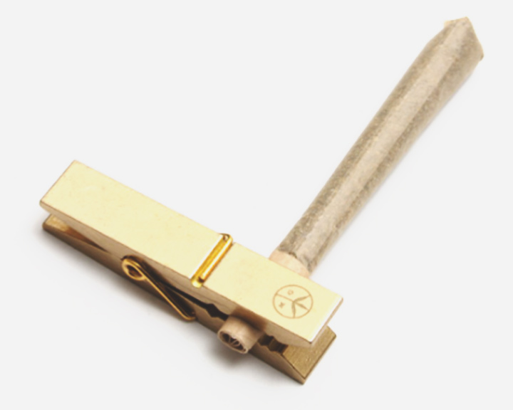 Brass Roach Clip Een gouden wasknijper met een houten handvat.