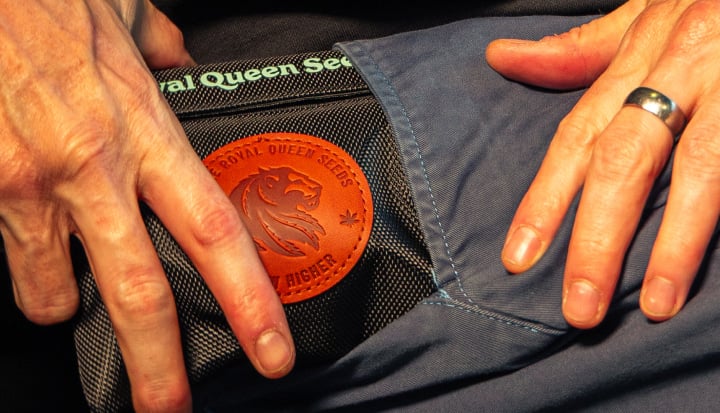 Afbeelding van handen die een geurvrije cannabis opbergtas in een zak stoppen.