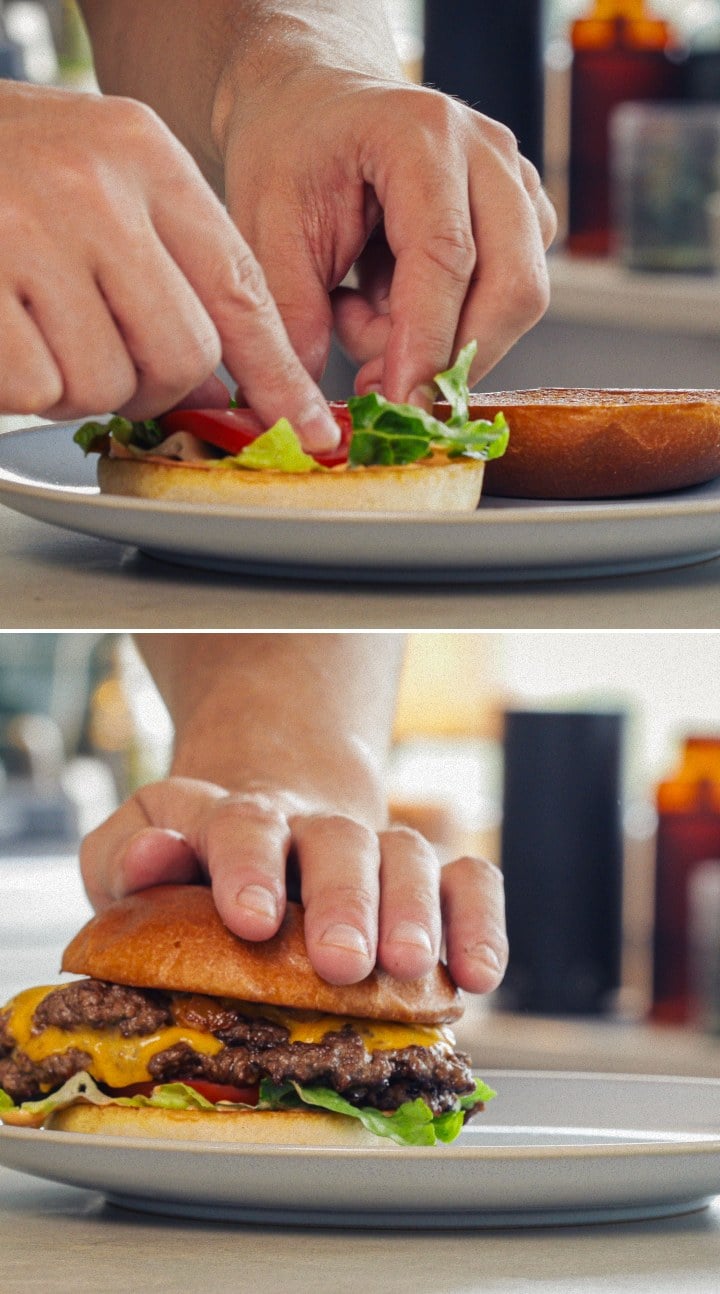 Samenstellen en serveren van een afgewerkte cannabisburger met gesmolten cheddar, sla, tomaat en een geïnfuseerd broodje