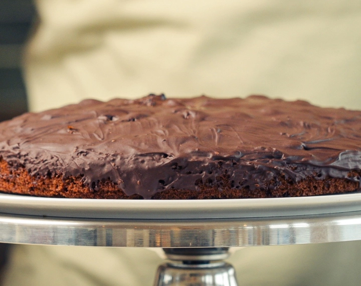Afgewerkte zelfgemaakte cannabis space cake met gesmolten pure chocolade, geserveerd als een klassiek edible dessert
